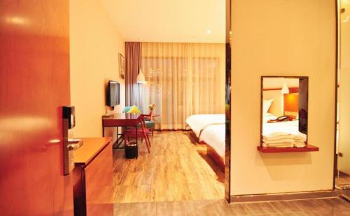 a hotel room with a bed and a mirror at Hangzhou Berman Hotel in Hangzhou