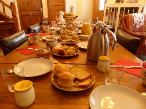 Una mesa de madera con platos de comida encima. en Demeure des tilleuls, en Locquénolé