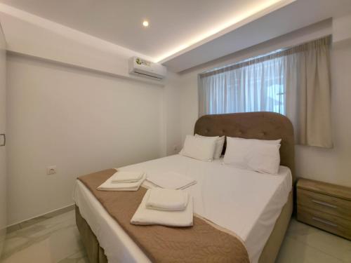 a bedroom with a bed with two towels on it at IFESTOS SUITES by SDR in Paralia Katerinis