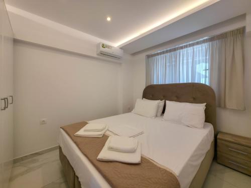 a bedroom with a bed with two towels on it at IFESTOS SUITES by SDR in Paralia Katerinis