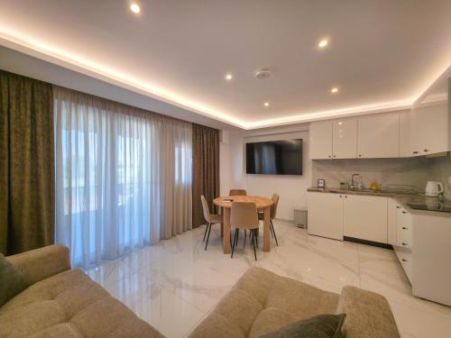 a living room with a kitchen and a dining room table at IFESTOS SUITES by SDR in Paralia Katerinis