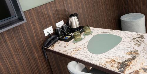 a bathroom with a sink and a phone on a counter at Hotel Europa Lignano in Lignano Sabbiadoro