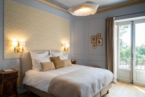 a bedroom with a large white bed with a window at Chateau Pascalette in La Londe-les-Maures