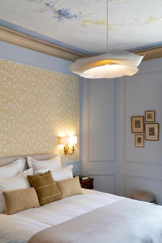 a bedroom with a white bed and a ceiling at Chateau Pascalette in La Londe-les-Maures