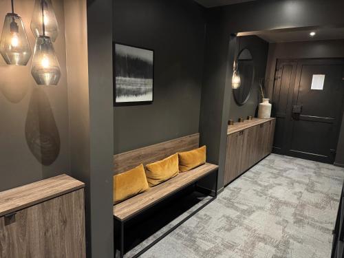 a hallway with a bench with yellow pillows on it at Førde Hotel - Unike Hoteller in Førde