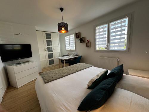 une chambre avec un grand lit et une télévision à écran plat dans l'établissement 2 Chambres chez l habitant à proximité baie du Mont Saint Michel Avranches, à Saint-Senier-sous-Avranches