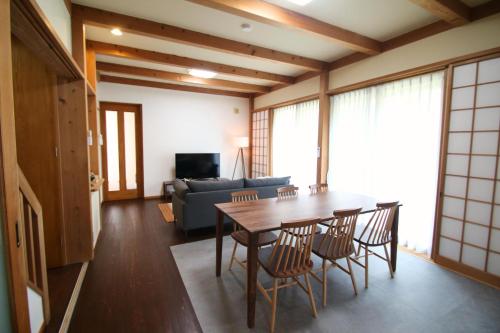 a living room with a table and chairs and a couch at Shinyashiki Guest House in Kumamoto