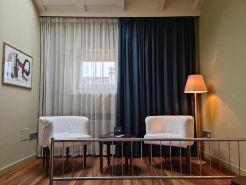 two chairs and a table in a room with a window at Palazzo Ai Capitani in Peschiera del Garda