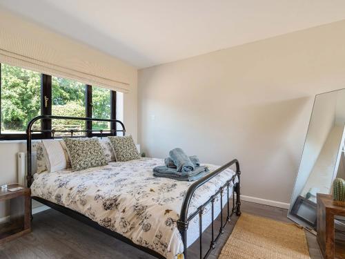 a bedroom with a bed and a window at Piglet Corner in Culmstock