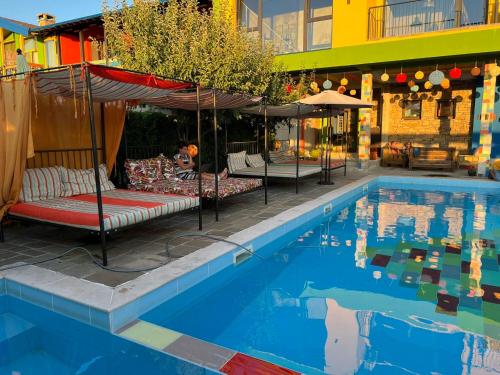 a pool with chairs and umbrellas next to a building at Hotel Casa Art in Oreshak
