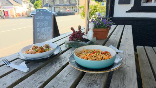 two bowls of food sitting on a wooden table at Y Gwydyr Hotel - Dolwyddelan in Dolwyddelan
