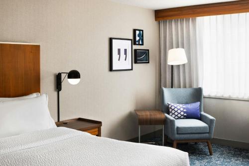 a hotel room with a bed and a chair at Four Points by Sheraton Halifax in Halifax