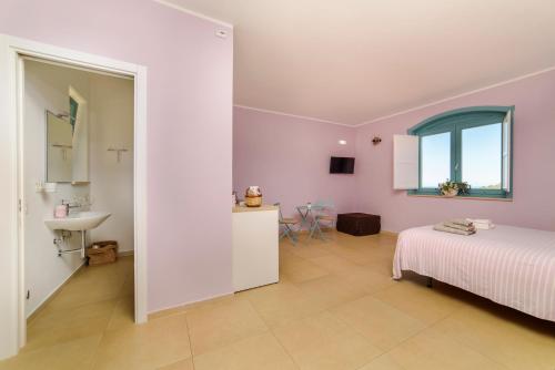 a bedroom with a bed and a sink and a window at Agriturismo Le Terre di Veneré in Acciaroli