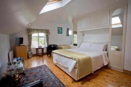 a bedroom with a large bed and a living room at Rosdarrig Bed & Breakfast in Boyle