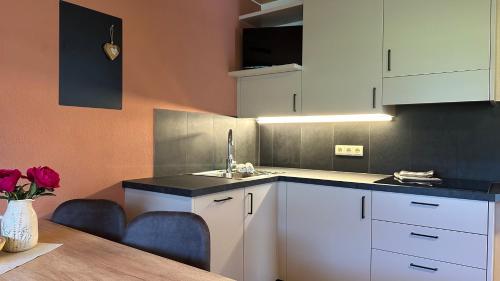 a kitchen with white cabinets and a table at Liebharterhof in Valdaora