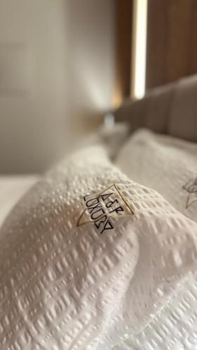 a close up of a white bed with aigil on it at A&F LUXURY Rooms Pinzolo in Pinzolo