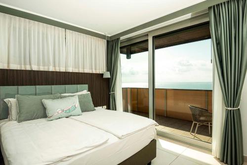 a bedroom with a bed and a balcony with the ocean at Hotel Europa Lignano in Lignano Sabbiadoro