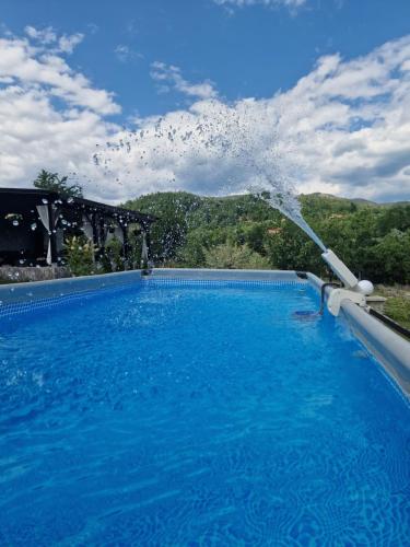 a water fountain in a swimming pool at Casa dintre munti in Novaci