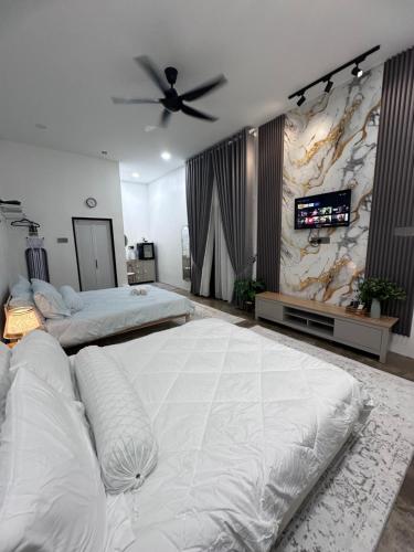 Un dormitorio grande con dos camas y un televisor de pantalla plana. en Rumah Petak Melor, en Gua Sai