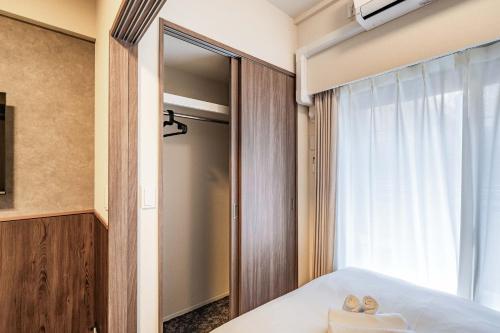 a bedroom with a mirror and a bed at Apartment Hotel 11 Higashi Umeda in Osaka