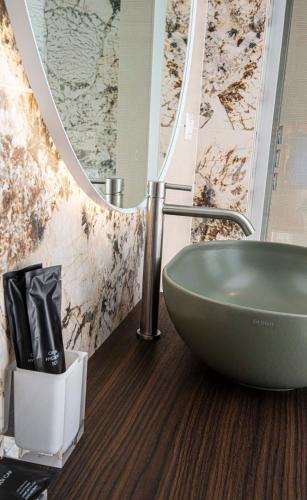 a bathroom with a green sink and a mirror at Hotel Europa Lignano in Lignano Sabbiadoro