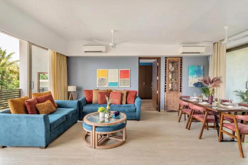 a living room with a blue couch and a table at Dia Hotels and Homes Nerul Goa - Villas and Apartments in Nerul