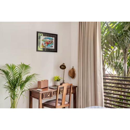 a room with a desk and a table and a window at Dia Hotels and Homes Nerul Goa - Villas and Apartments in Nerul