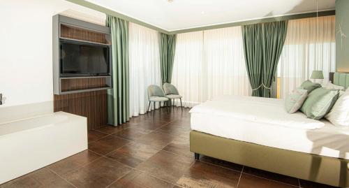 a hotel room with a bed and a television at Hotel Europa Lignano in Lignano Sabbiadoro