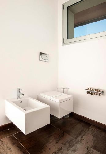 a white bathroom with a sink and a mirror at Hotel Europa Lignano in Lignano Sabbiadoro