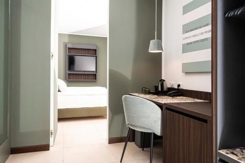 a kitchen with a counter and a room with a bed at Hotel Europa Lignano in Lignano Sabbiadoro