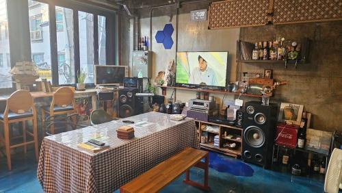 a room with a room with a table and speakers at Pohang Poderosa Blue Guesthouse in Pohang