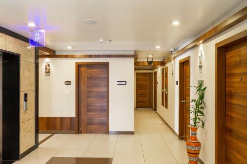 a hallway with wooden doors and tile floors at Hotel Crystals Cove in Thekkady