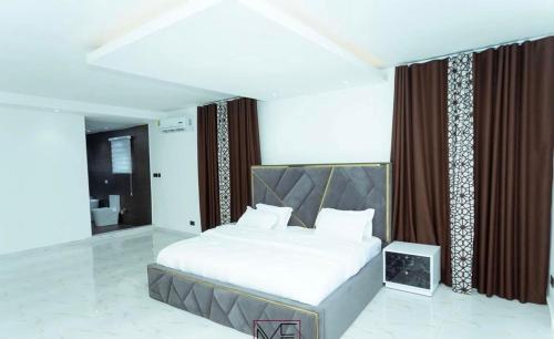 a bedroom with a large bed and a bathroom at Enak homes in Miocho