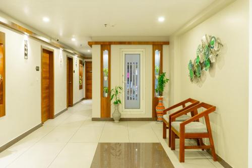 a hallway with a door and a chair and a staircase at Hotel Crystals Cove in Thekkady