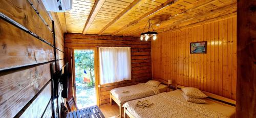 a room with two beds in a wooden cabin at Casa Moața La Vama Veche in Vama Veche