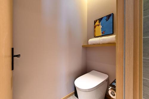 a small bathroom with a toilet and a shower at Atour Hotel Dalian Hi-tech Zone in Dalian