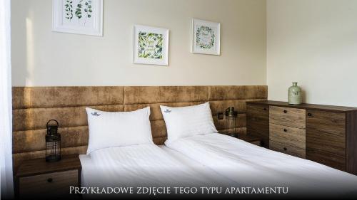 a bedroom with a bed with white sheets and pillows at Norweska Dolina Family&Pet-friendly Resort in Szklarska Poręba