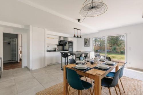 une salle à manger et une cuisine avec une table et des chaises dans l'établissement Appartement avec Jacuzzi spacieux et lumineux au cœur de Chiberta, à Anglet