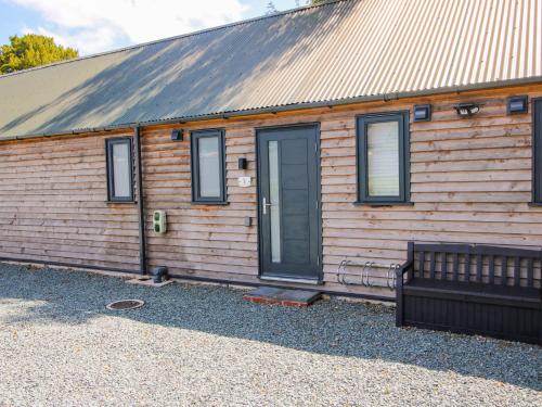 a wooden house with a bench in front of it at Stiper View Barn 1 in Shrewsbury