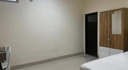 a white room with a bed and a window at Hotel O Penginapan Hj Lilis 2 Syariah in Sukabumi