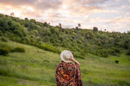 a woman wearing a hat walking down a grassy hill at Tiny Georgie in Picton