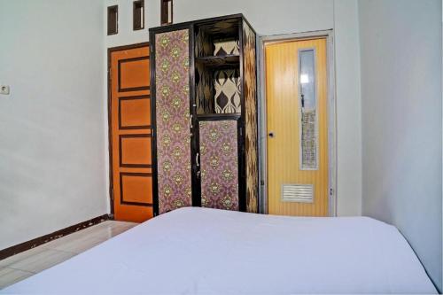 a bedroom with a bed and an open door at Hotel O Penginapan Hj Lilis 2 Syariah in Sukabumi