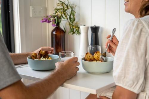 two people sitting at a table with bowls of food at Tiny Georgie in Picton