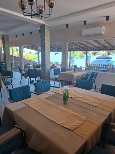 a banquet hall with tables and blue chairs and tablesktop at Villa&Restaurant Strmec in Elshani