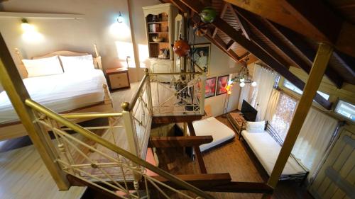 an attic bedroom with a bed and a spiral staircase at ART HOUSE in Parga