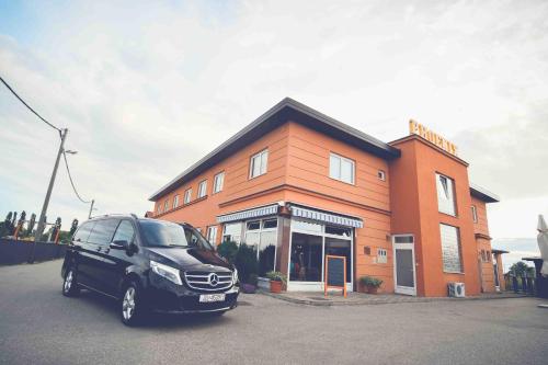 a black car parked in front of a building at Hotel Phoenix in Velika Gorica