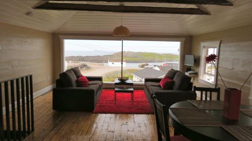 a living room with two couches and a large window at The Old Salt Box Co. - Mary's Place in Fogo