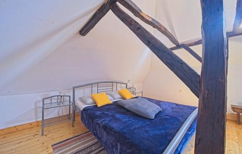 a bedroom with a bed with blue sheets and yellow pillows at Beautiful Holiday Home Martinscak in Gornji Velemerić