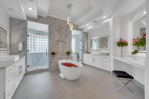 フォート・ローダーデールにあるMediterranean Villa Venice of America Riverside View Access Fiesta Key VlLLASの白いバスルーム(大型バスタブ、シャワー付)
