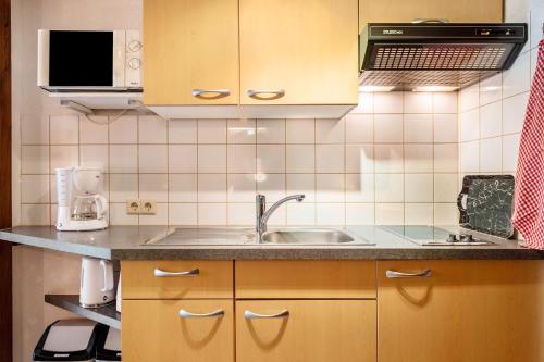 a kitchen with a sink and a microwave at Gästehaus Gaby in Bad Bellingen